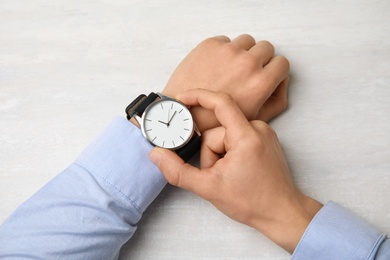 Photo of Businessman with stylish wrist watch at table, top view