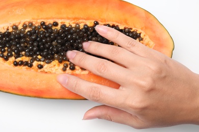 Photo of Young woman touching half of papaya on white background, closeup. Sex concept