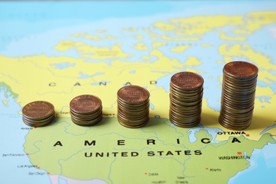 Photo of Different stacks of coins near USA on world map