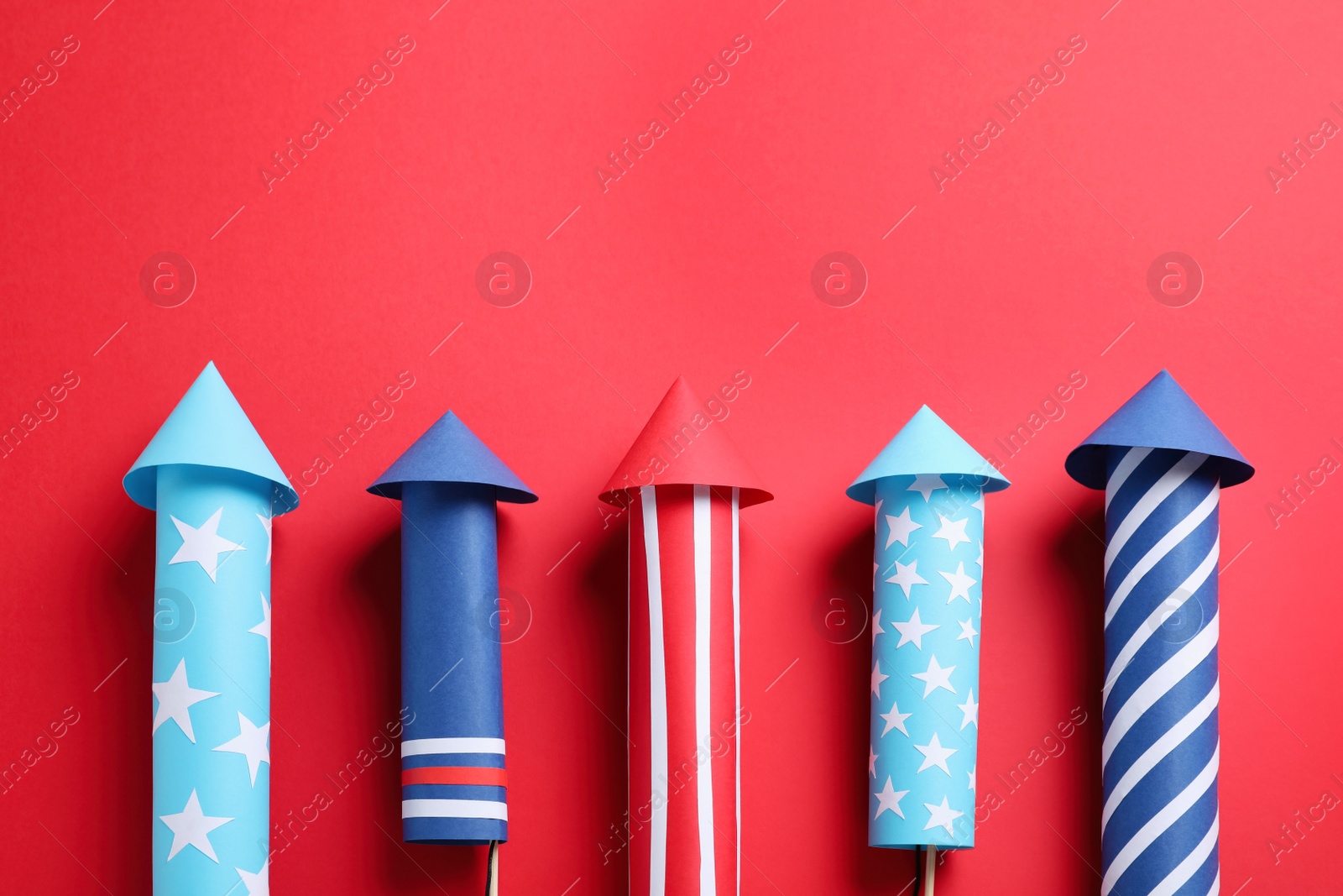 Photo of Firework rockets on red background, space for text