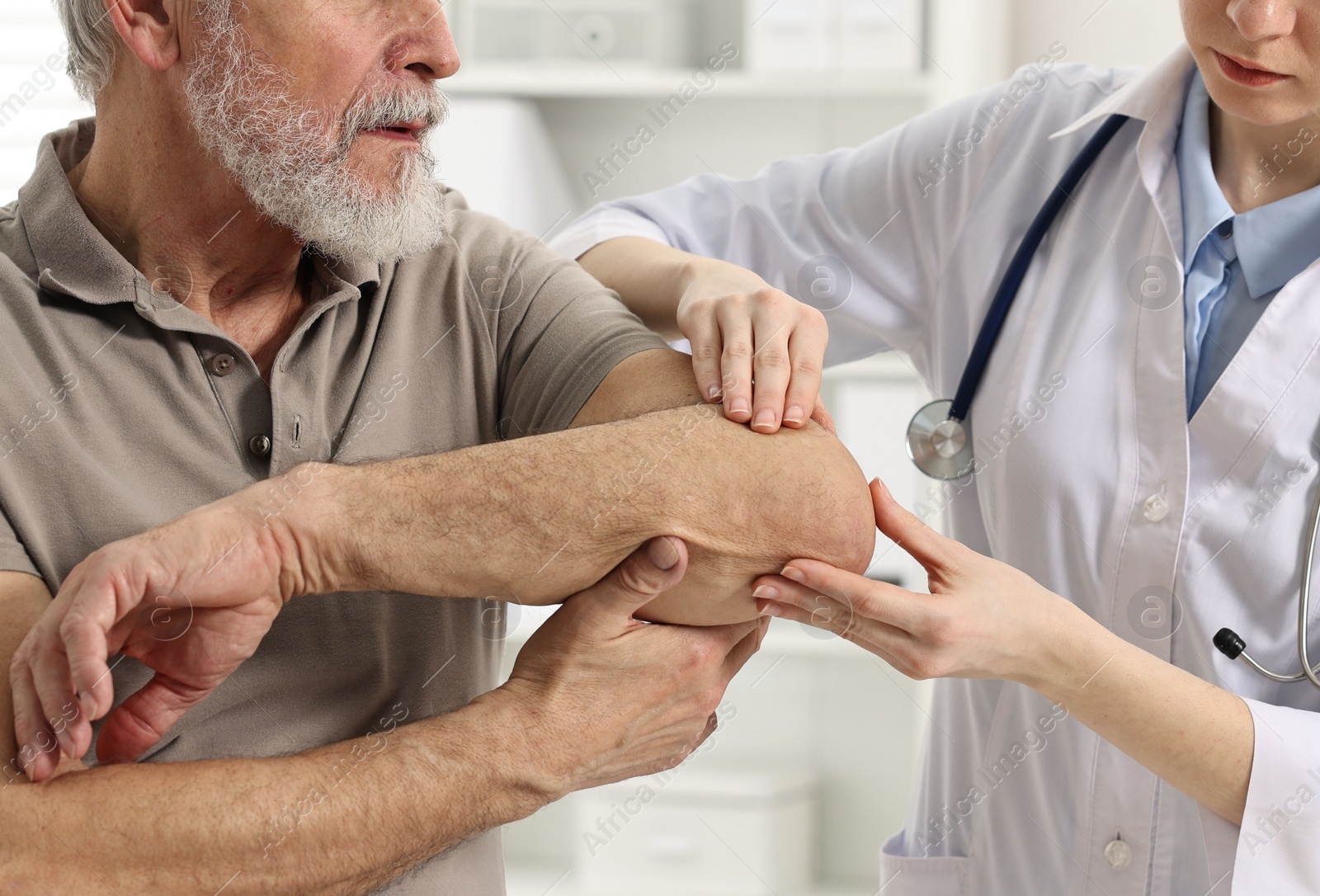 Photo of Arthritis symptoms. Doctor examining patient's elbow in hospital