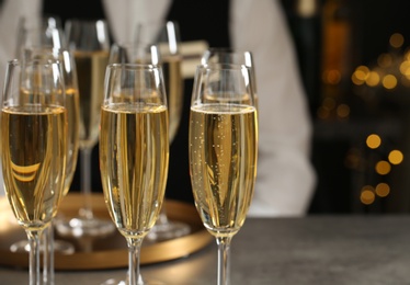 Photo of Glasses of champagne and waiter in restaurant, closeup. Space for text