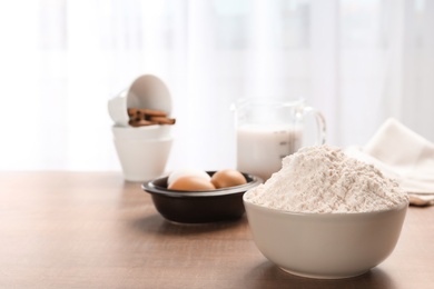 Photo of Bowl with flour on kitchen table