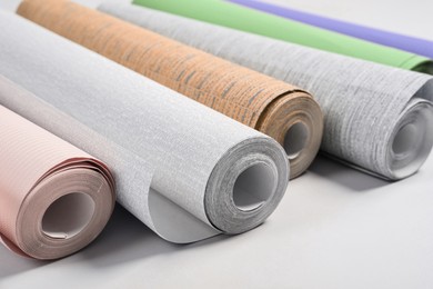 Image of Different wallpaper rolls on light grey background, closeup