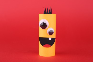 Photo of Spooky paper monster on red background. Handmade Halloween decoration