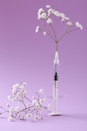 Cosmetology. Medical syringe and gypsophila on violet background