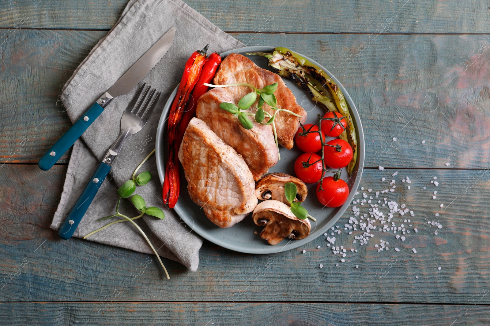 Photo of Delicious grilled meat and vegetables served on wooden table, flat lay