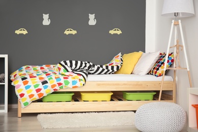 Photo of Modern room interior with comfortable bed for child