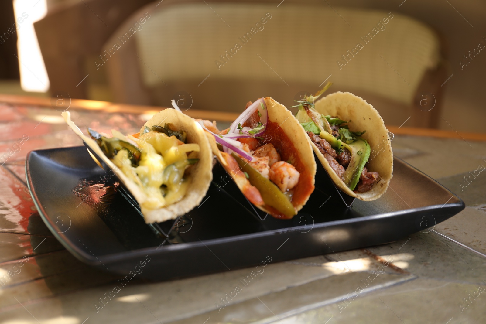 Photo of Delicious tacos with shrimps and vegetables on table