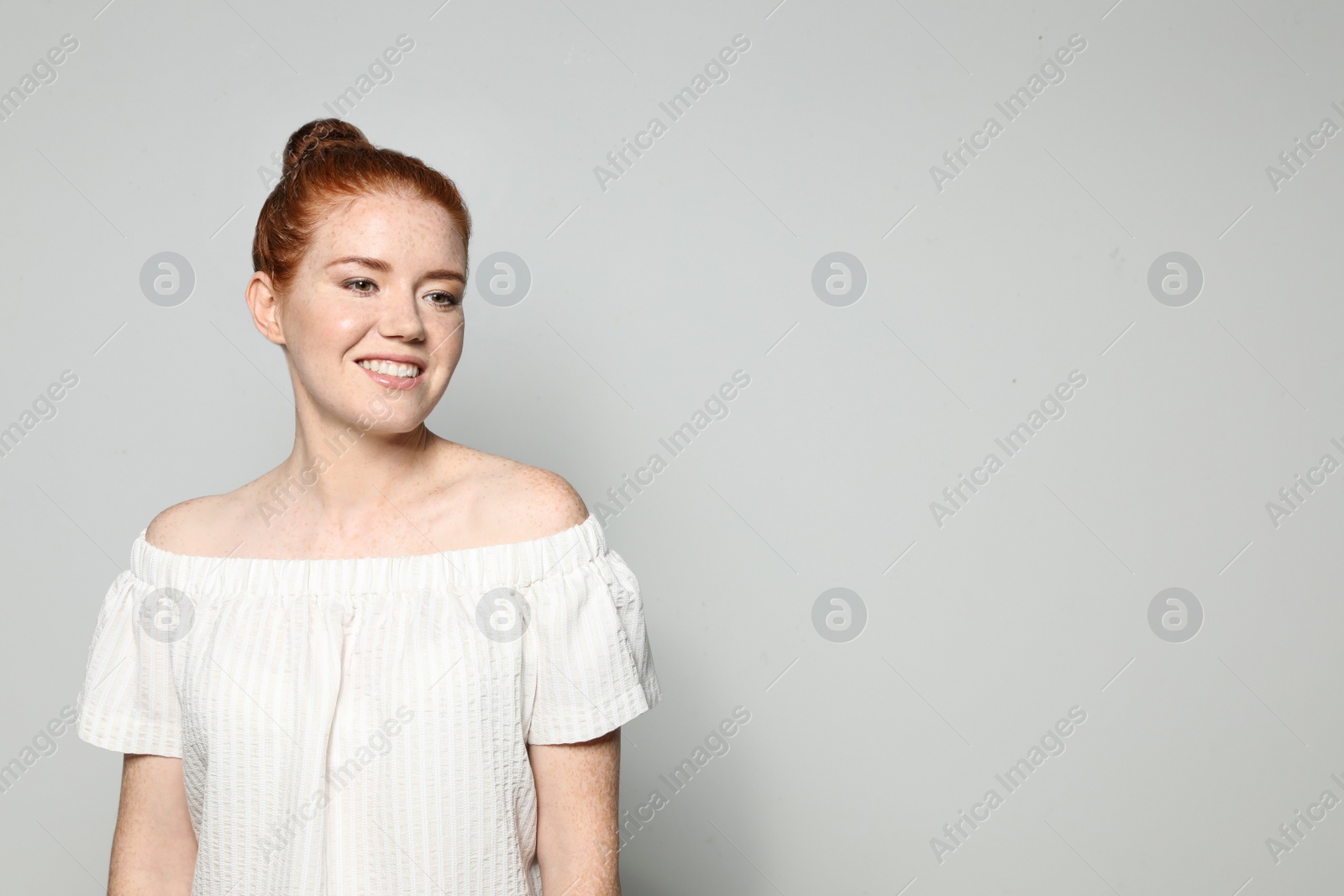 Photo of Portrait of young woman with beautiful face on grey background. Space for text