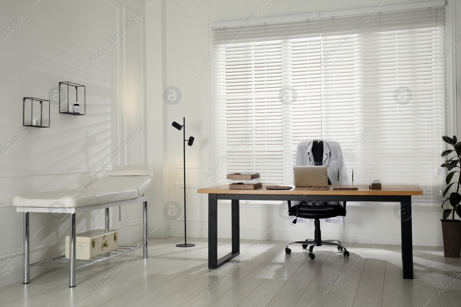 Photo of Modern medical office interior with doctor's workplace and examination table