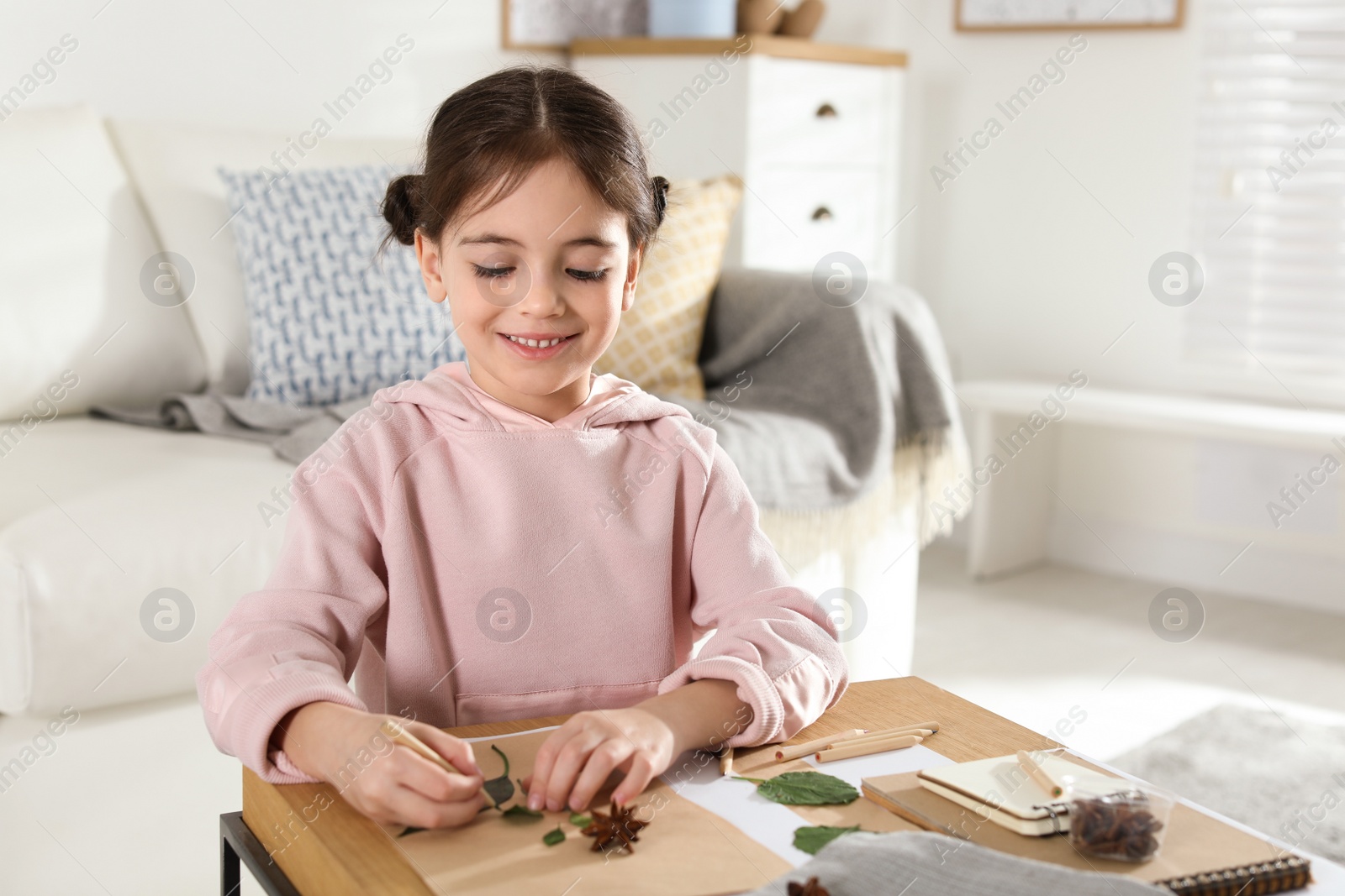 Photo of Little girl working with natural materials at table indoors. Creative hobby