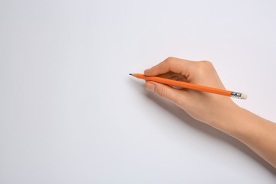 Woman with new graphite pencil on white background, closeup. Space for text