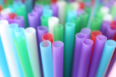 Heap of colorful plastic straws for drinks as background, closeup