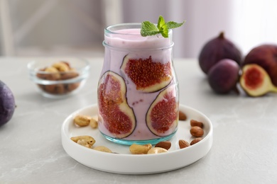 Photo of Delicious fig smoothie in glass jar on light table