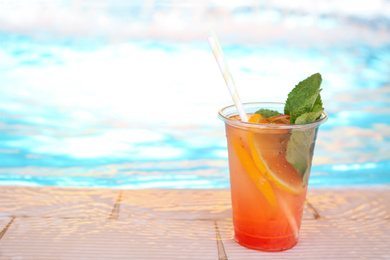 Photo of Delicious refreshing drink near swimming pool. Space for text