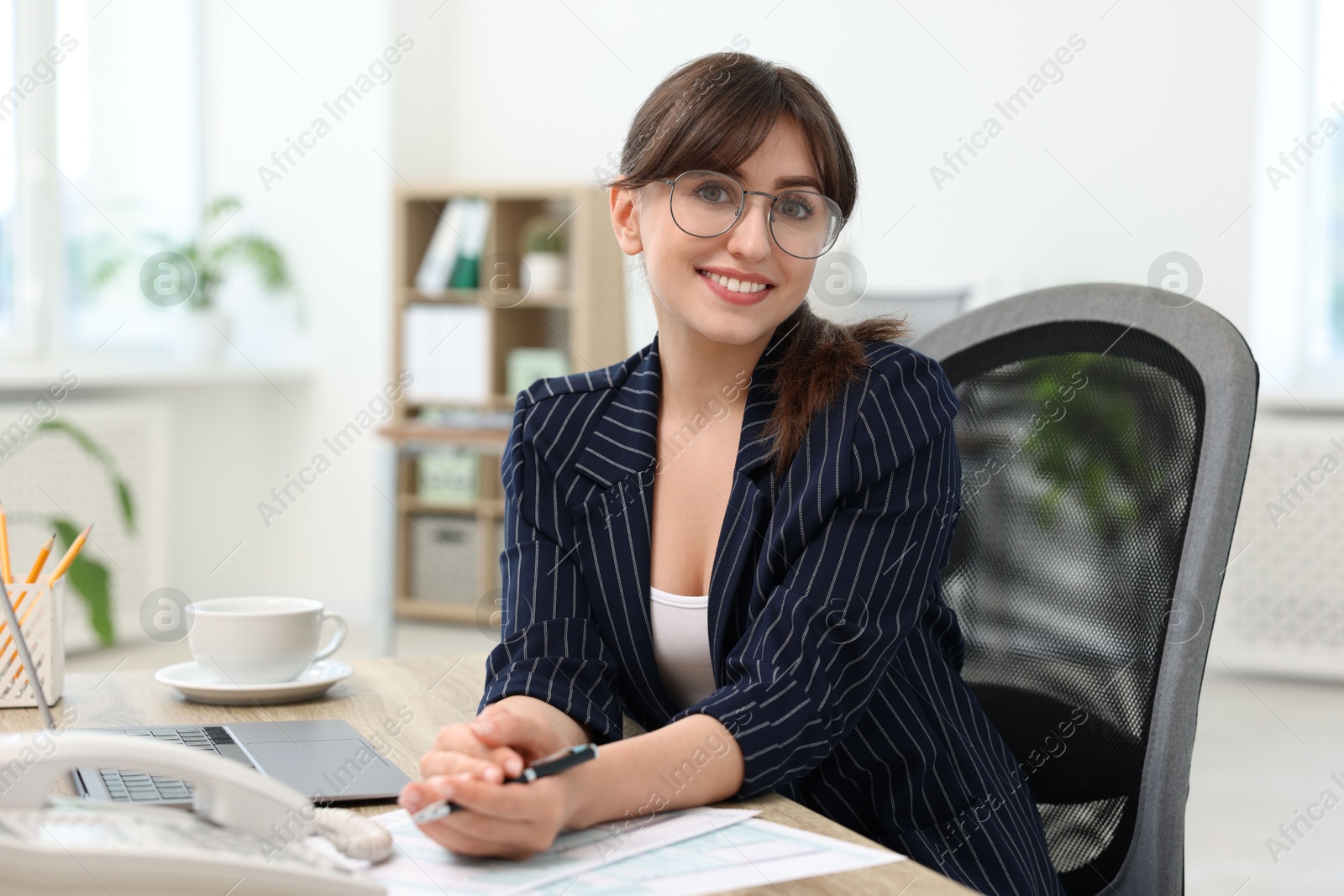 Photo of Portrait of smiling secretary at table in office