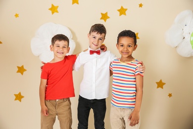 Adorable little boys and decor for birthday party on color background