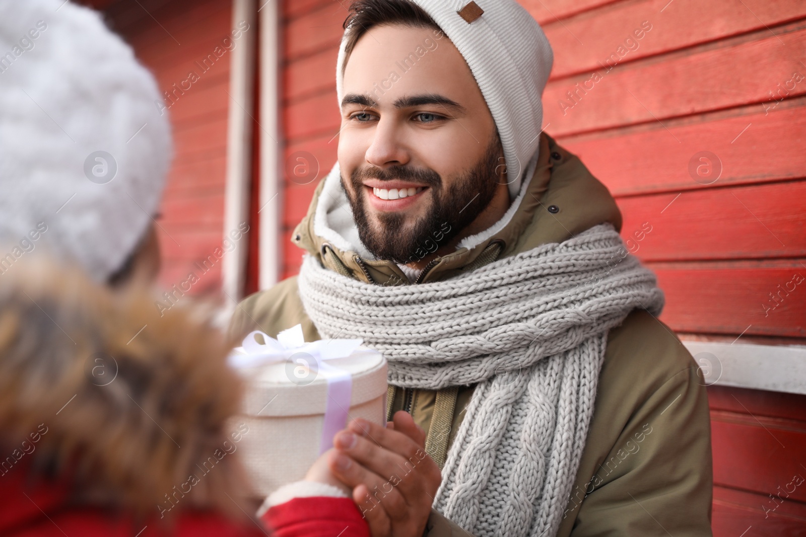 Photo of Happy young couple with gift box at winter fair. Christmas celebration