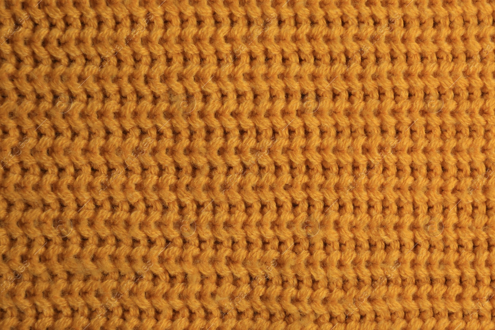 Photo of Beautiful orange knitted fabric as background, top view