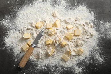 Photo of Making shortcrust pastry. Flour, butter and knife on grey table, top view