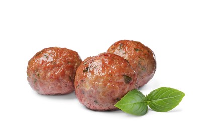 Photo of Many tasty cooked meatballs with basil on white background