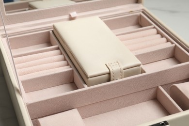 Photo of Empty beige jewelry box on table, closeup