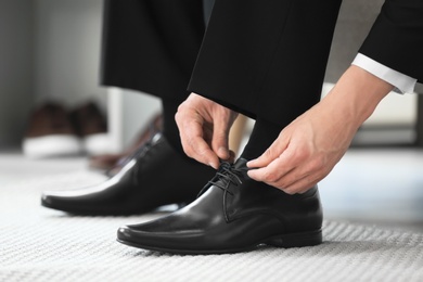 Photo of Young man trying on shoes in store