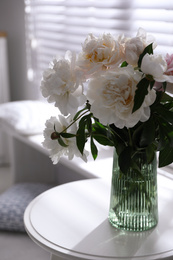 Photo of Bouquet of beautiful peony flowers on table indoors