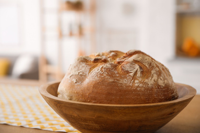 Bowl with fresh bread on table in kitchen, closeup