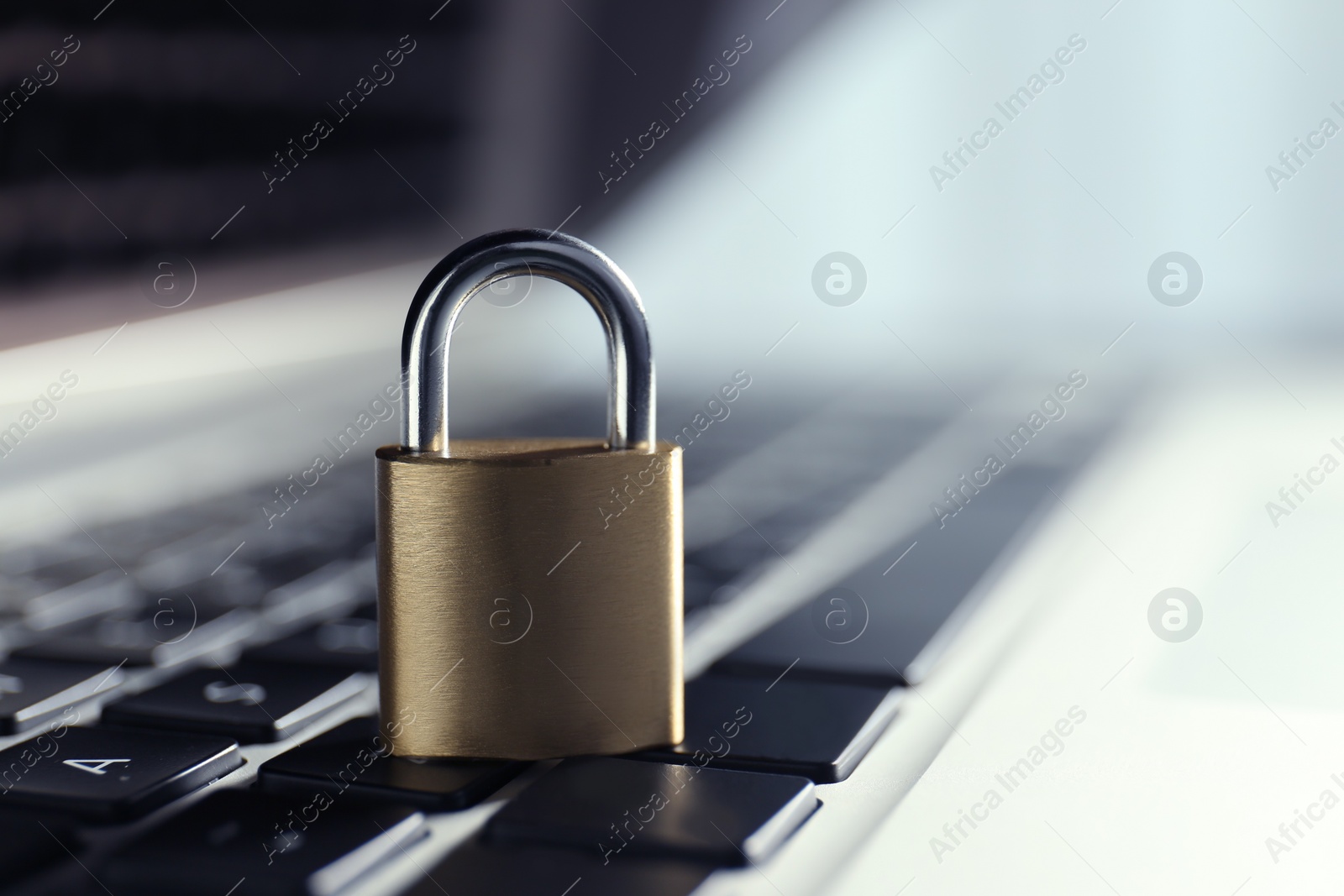 Photo of Metal padlock on laptop keyboard, space for text. Cyber security concept