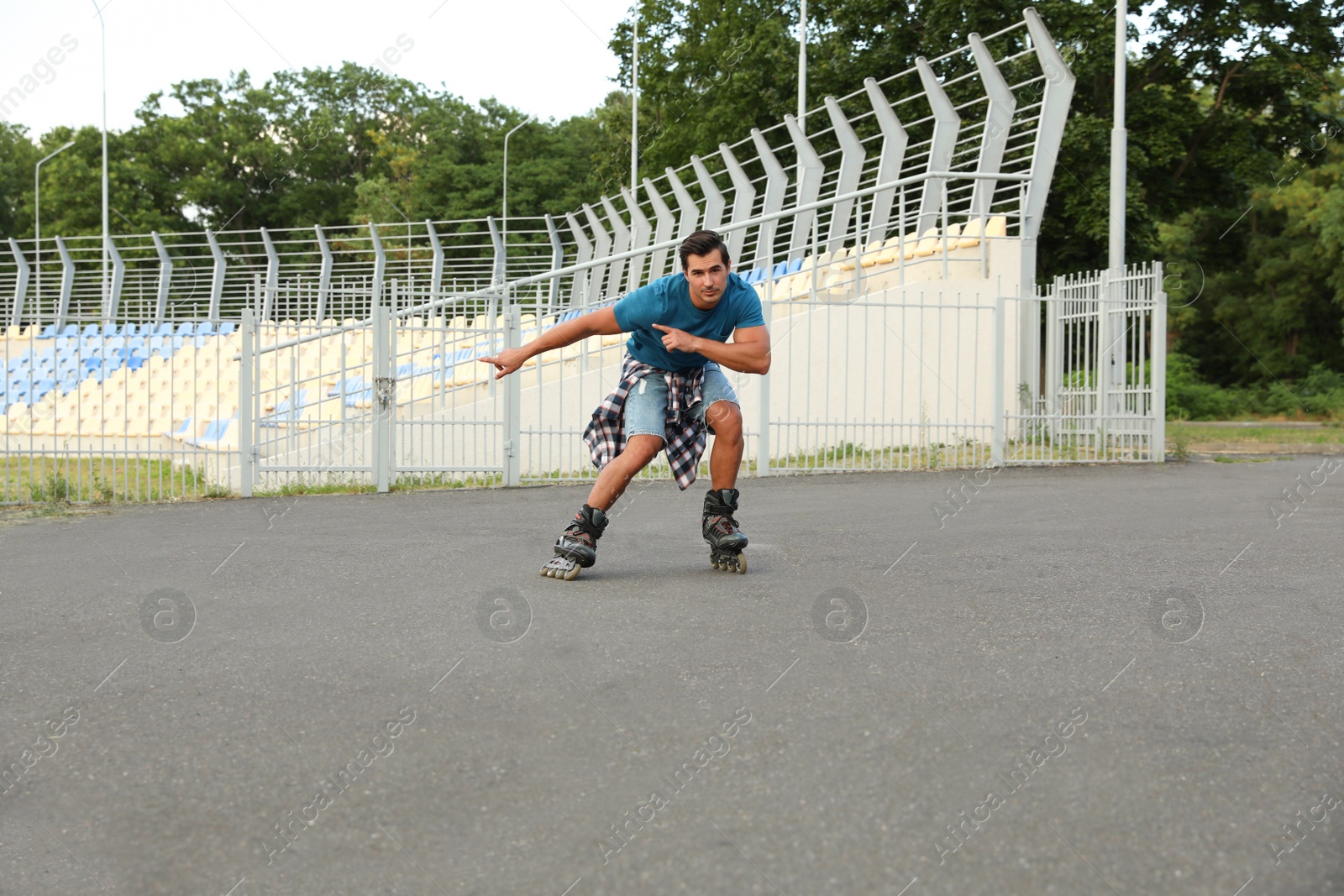 Photo of Handsome young man roller skating outdoors. Recreational activity