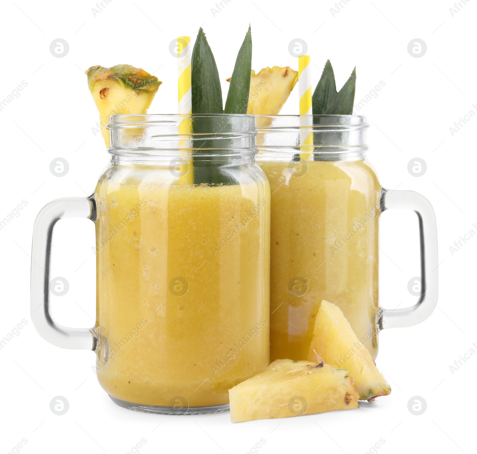 Photo of Tasty pineapple smoothie in mason jars and sliced fruit isolated on white