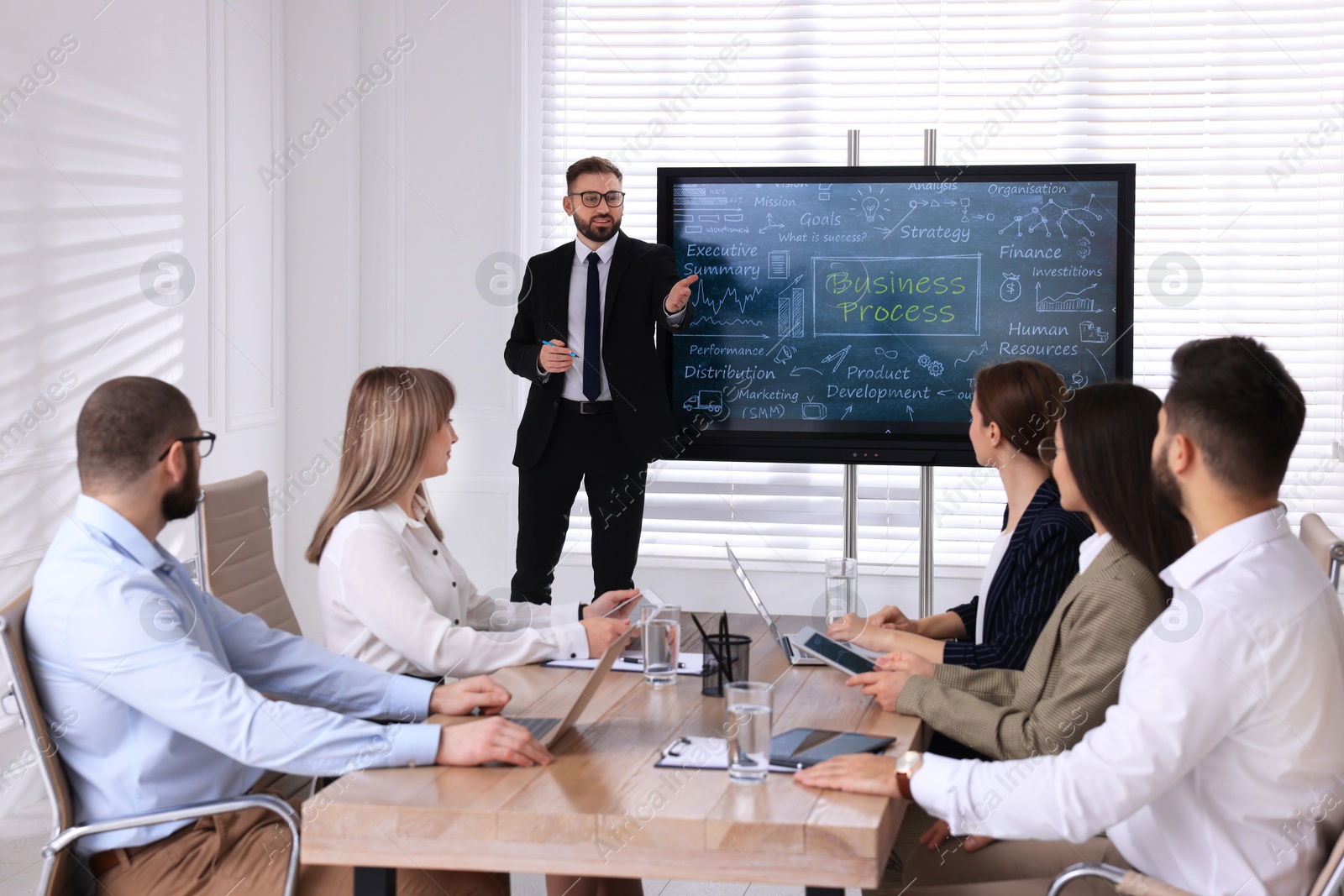 Photo of Business trainer near interactive board in meeting room during presentation