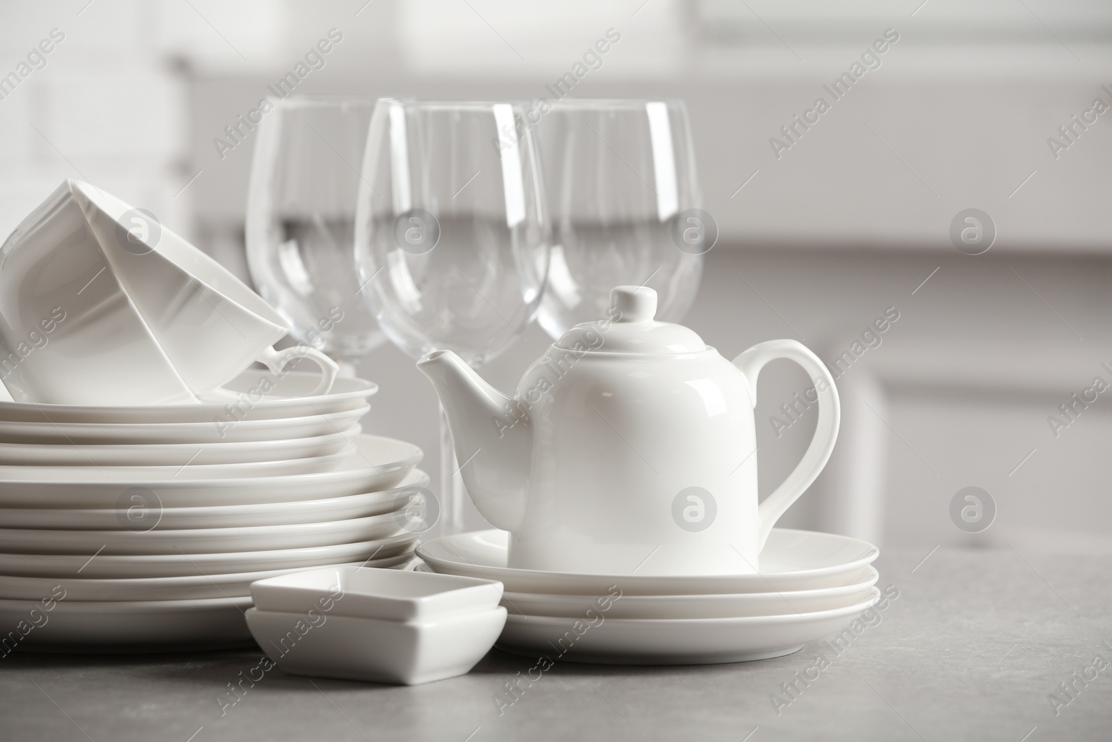 Photo of Set of clean dishes on table against blurred background