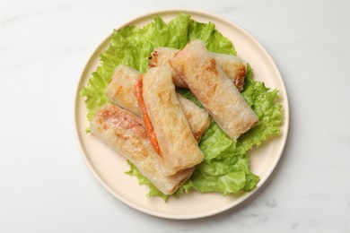 Photo of Delicious fried spring rolls on white table, top view