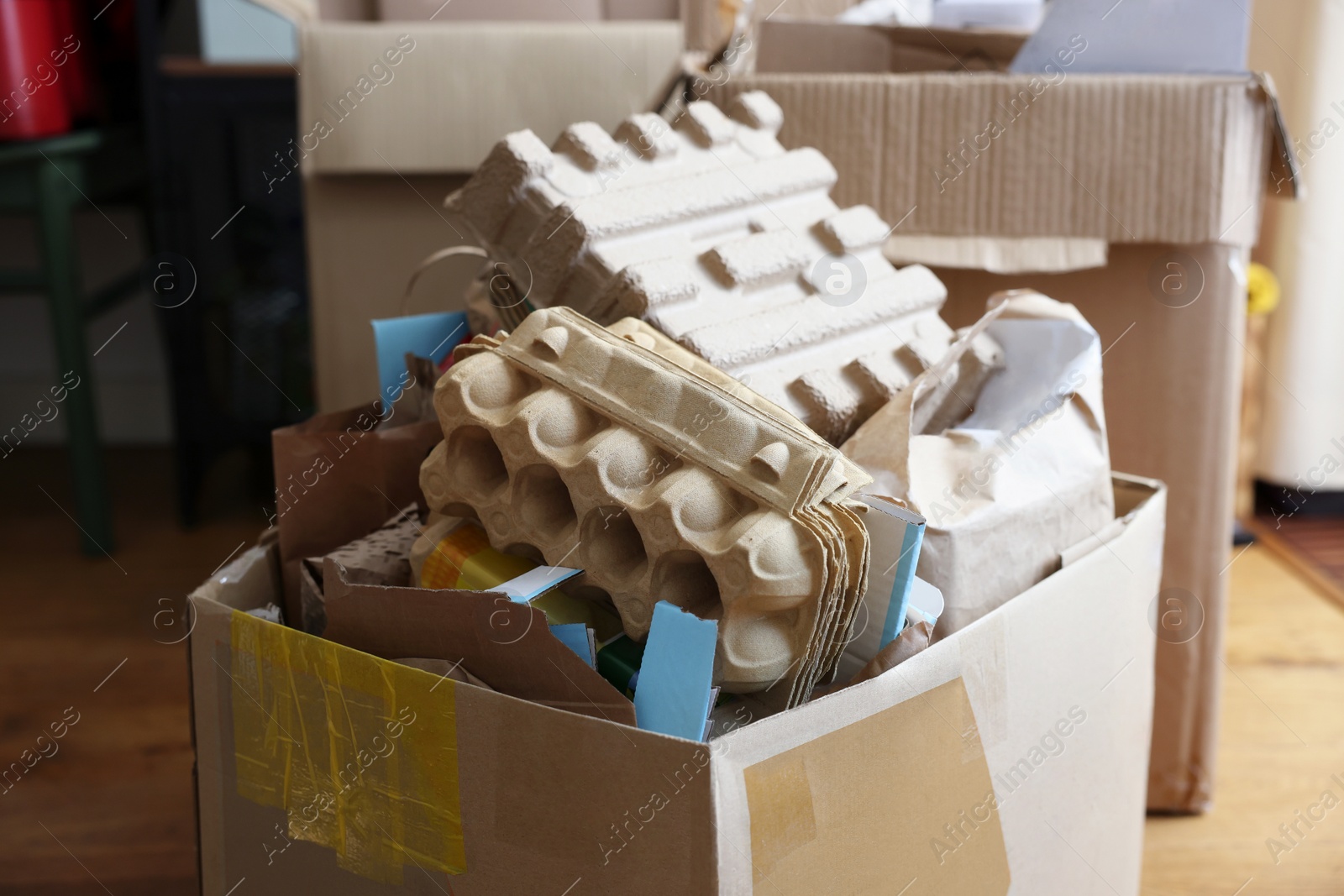 Photo of Reuse concept. Different trash in cardboard boxes for recycling indoors