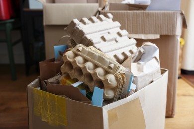 Photo of Reuse concept. Different trash in cardboard boxes for recycling indoors