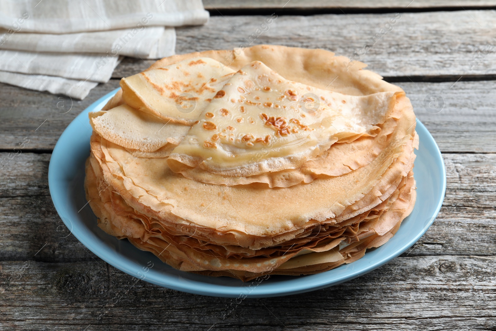 Photo of Stack of delicious crepes on wooden table