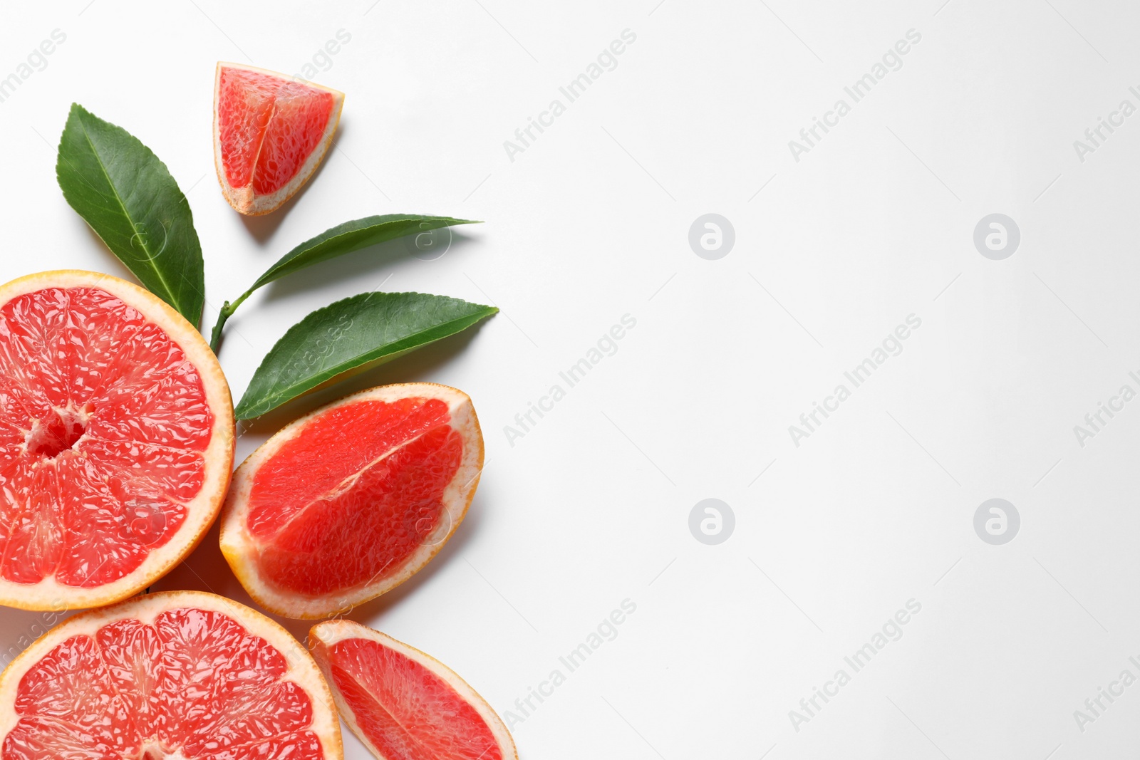 Photo of Grapefruits and leaves on white background, top view. Citrus fruits