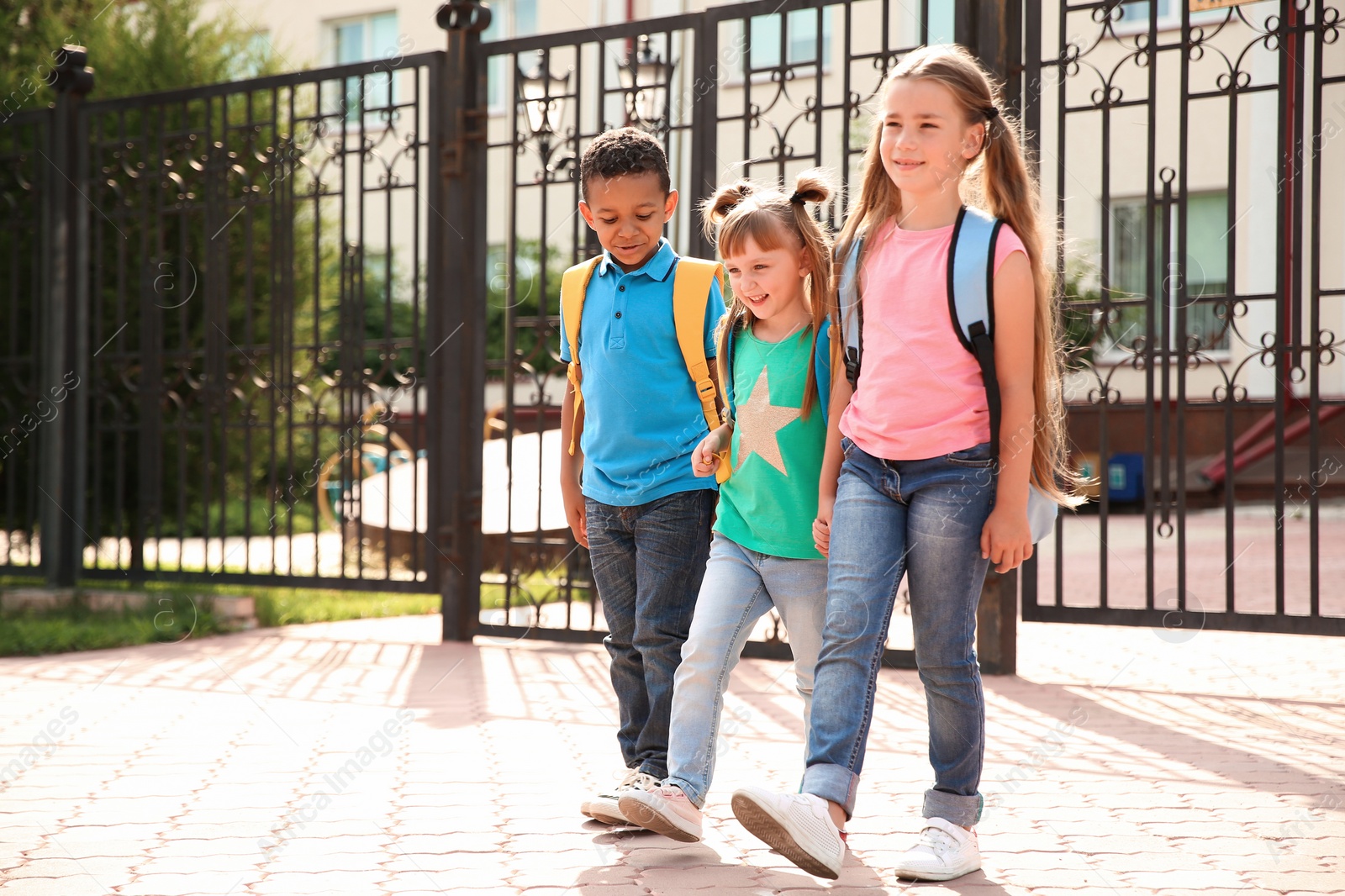 Photo of Cute little children with backpacks going to school