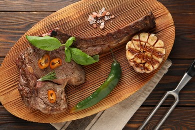 Photo of Delicious fried beef meat served on wooden table, flat lay