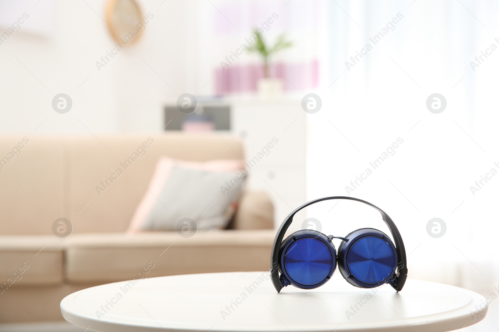 Photo of Stylish headphones on table indoors. Space for text