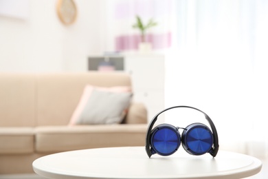 Photo of Stylish headphones on table indoors. Space for text