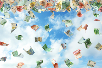 Image of Falling Euro banknotes and blue sky on background. Money rain 