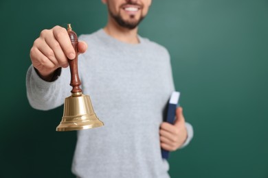 Photo of Teacher with school bell near chalkboard, closeup, space for text