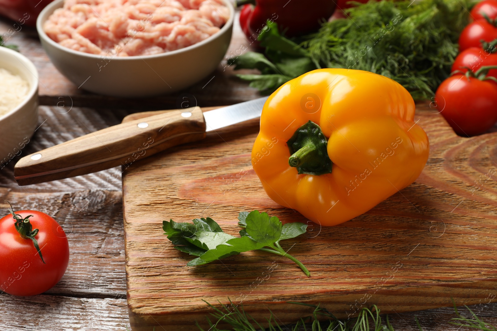 Photo of Making stuffed peppers. Ground meat and other ingredients on wooden table