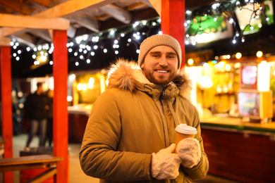 Photo of Happy man with drink at Christmas fair