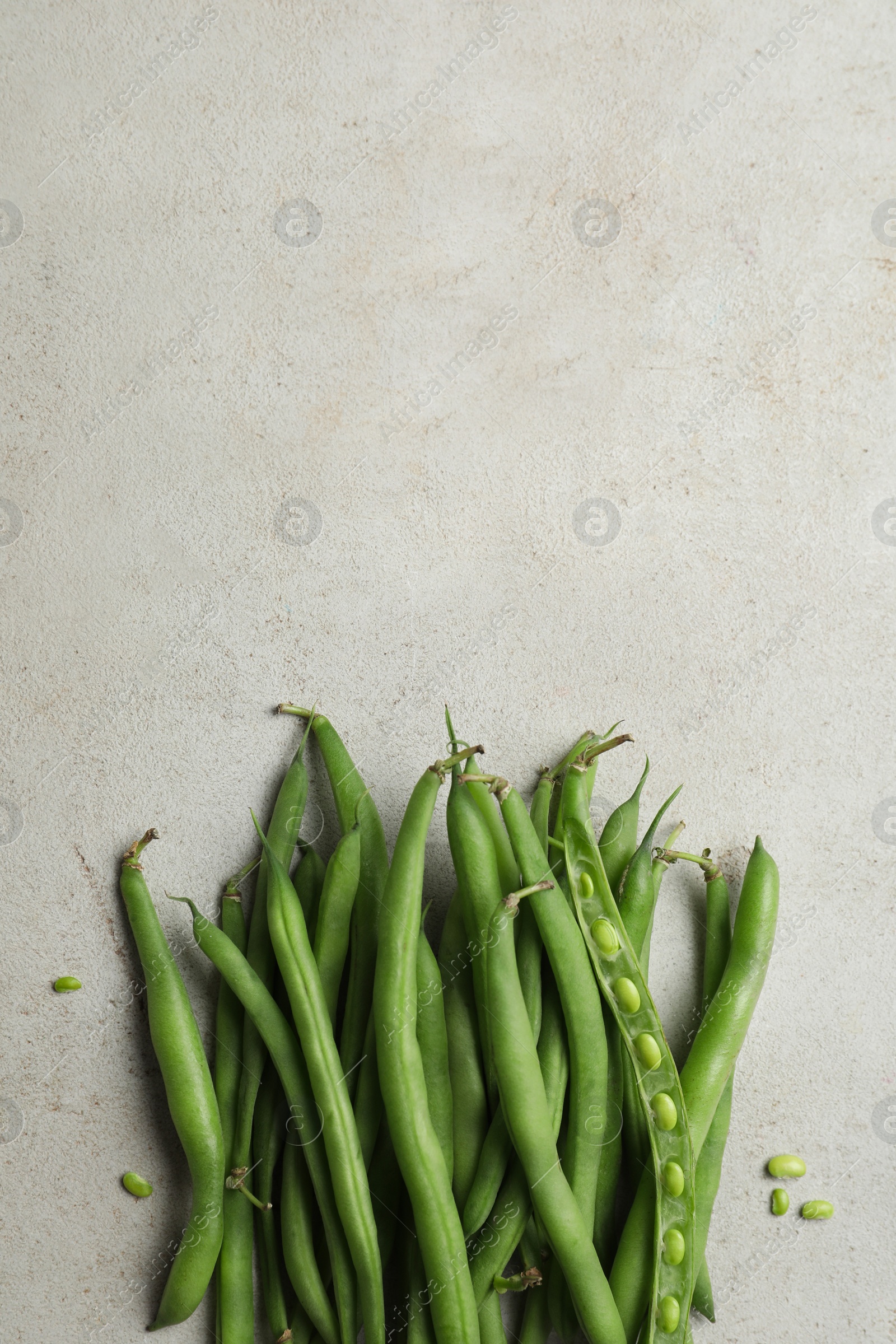 Photo of Fresh green beans on light grey table, flat lay. Space for text