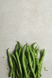 Photo of Fresh green beans on light grey table, flat lay. Space for text